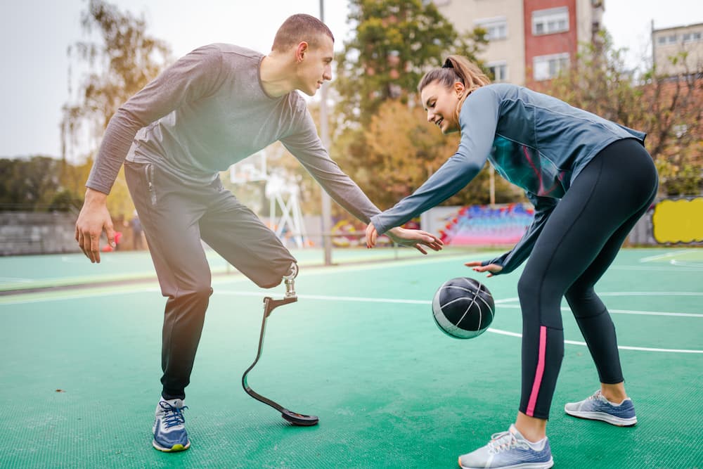 man with one leg playing basketball with a woman